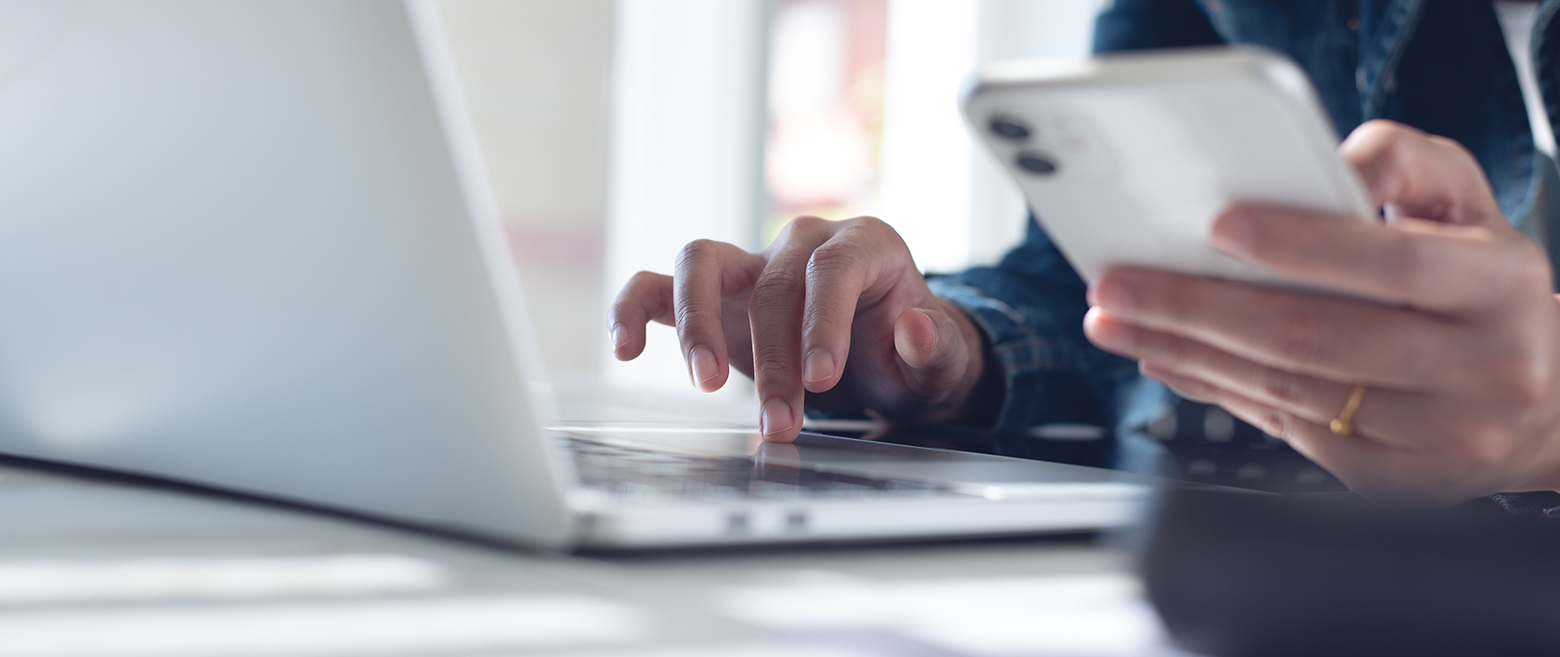  Image of person checking phone and laptop