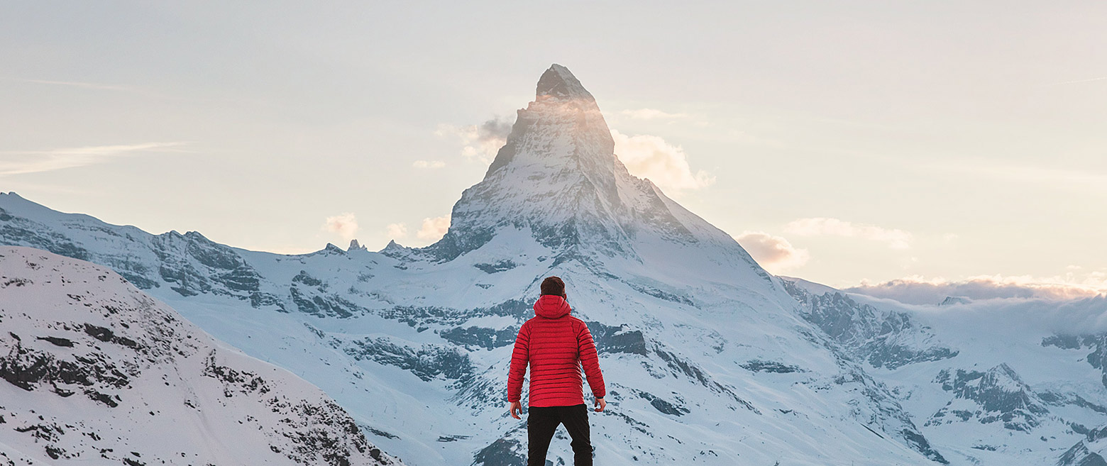 Image of a man standing under a mountain peak