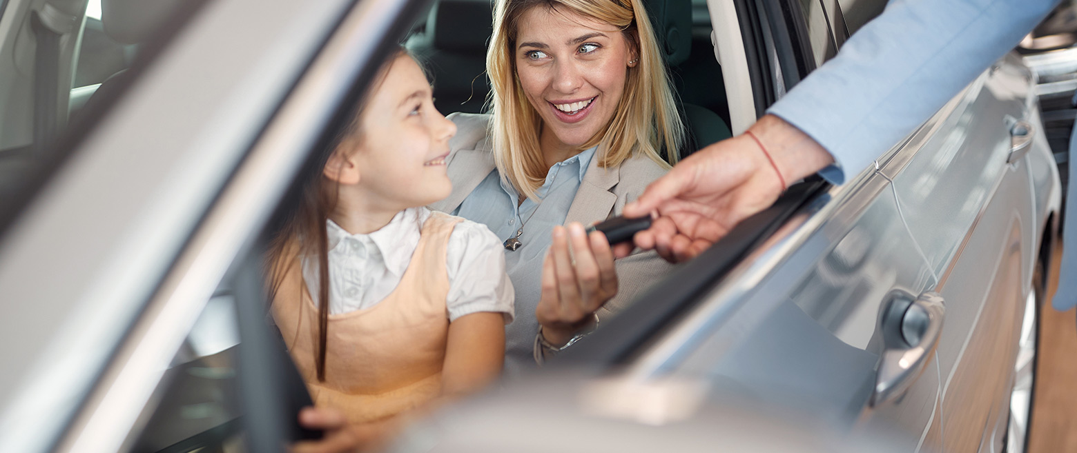 Woman and her child paying with a credit card in their car.