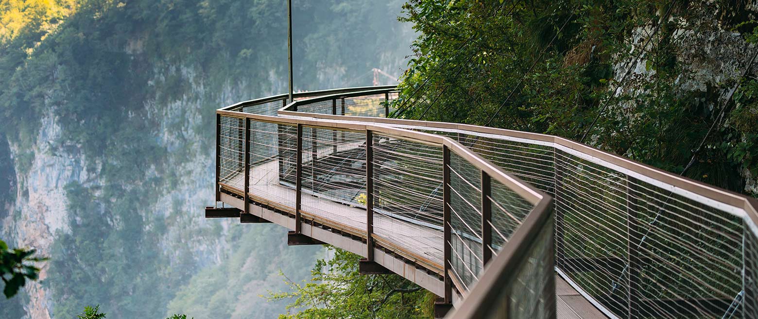 A wooden walking bridge on the side of a cliff.