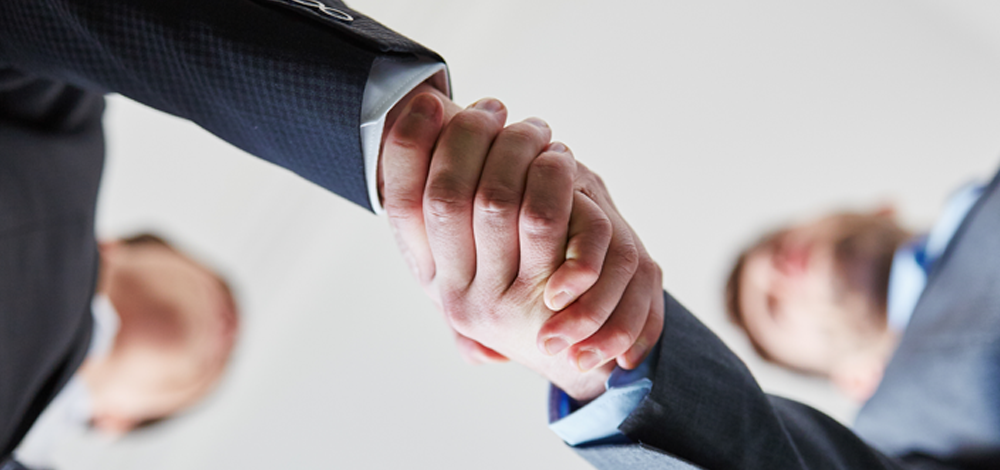 Two men in suits shaking hands