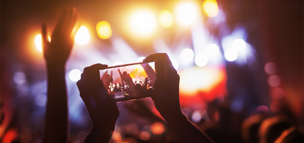 Person taking a video on phone at concert