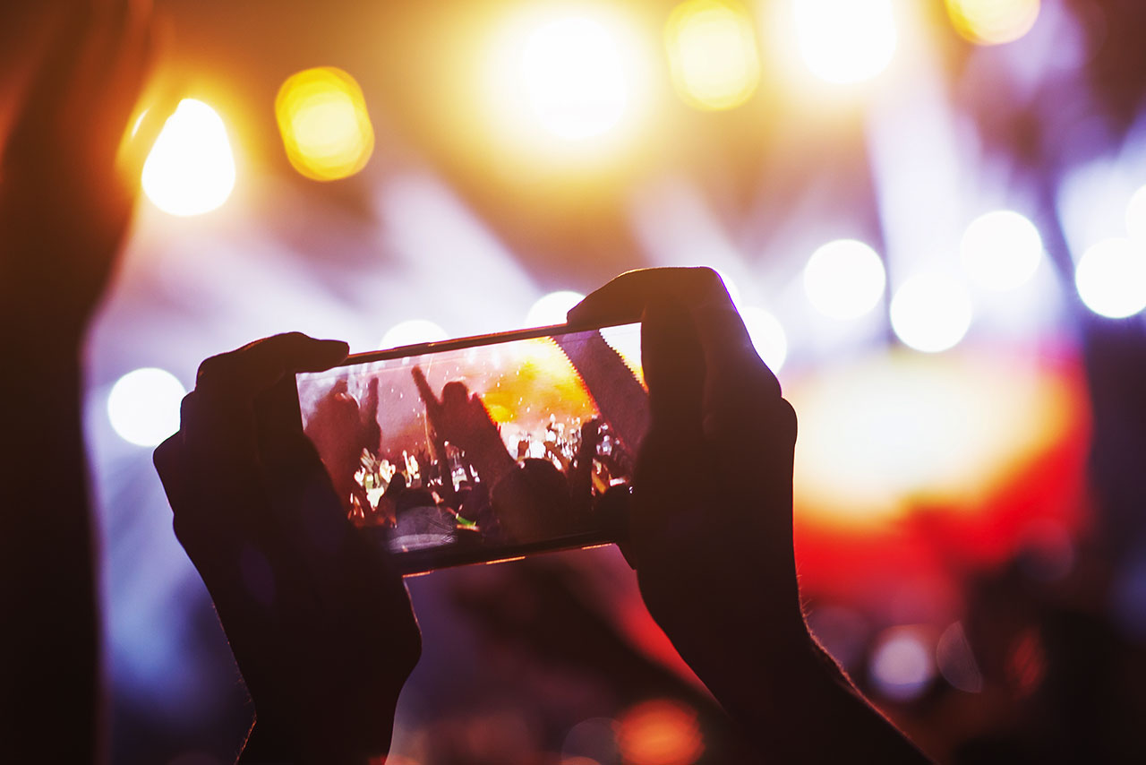 a person taking a photo at a concert