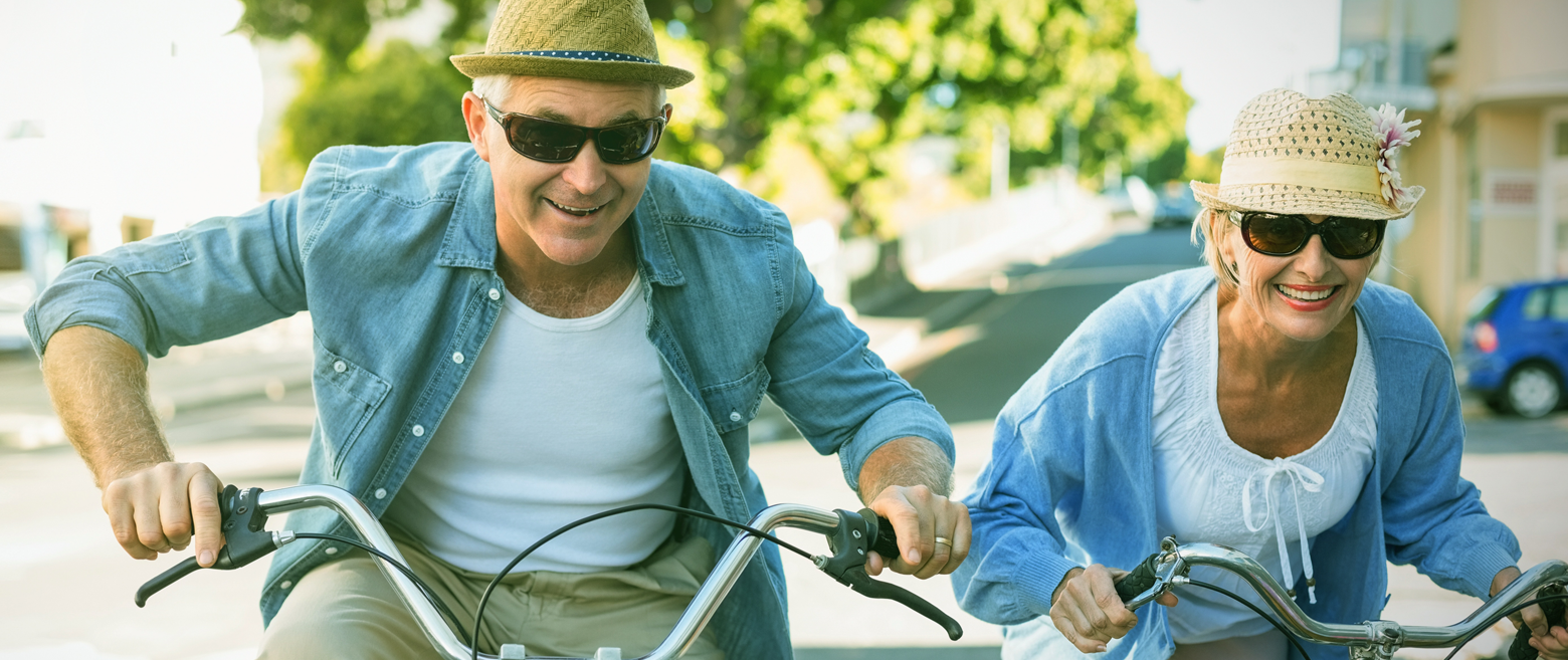 Elderly couple riding their bicycles.
