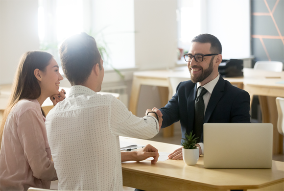 Image of a couple with a loan representative.