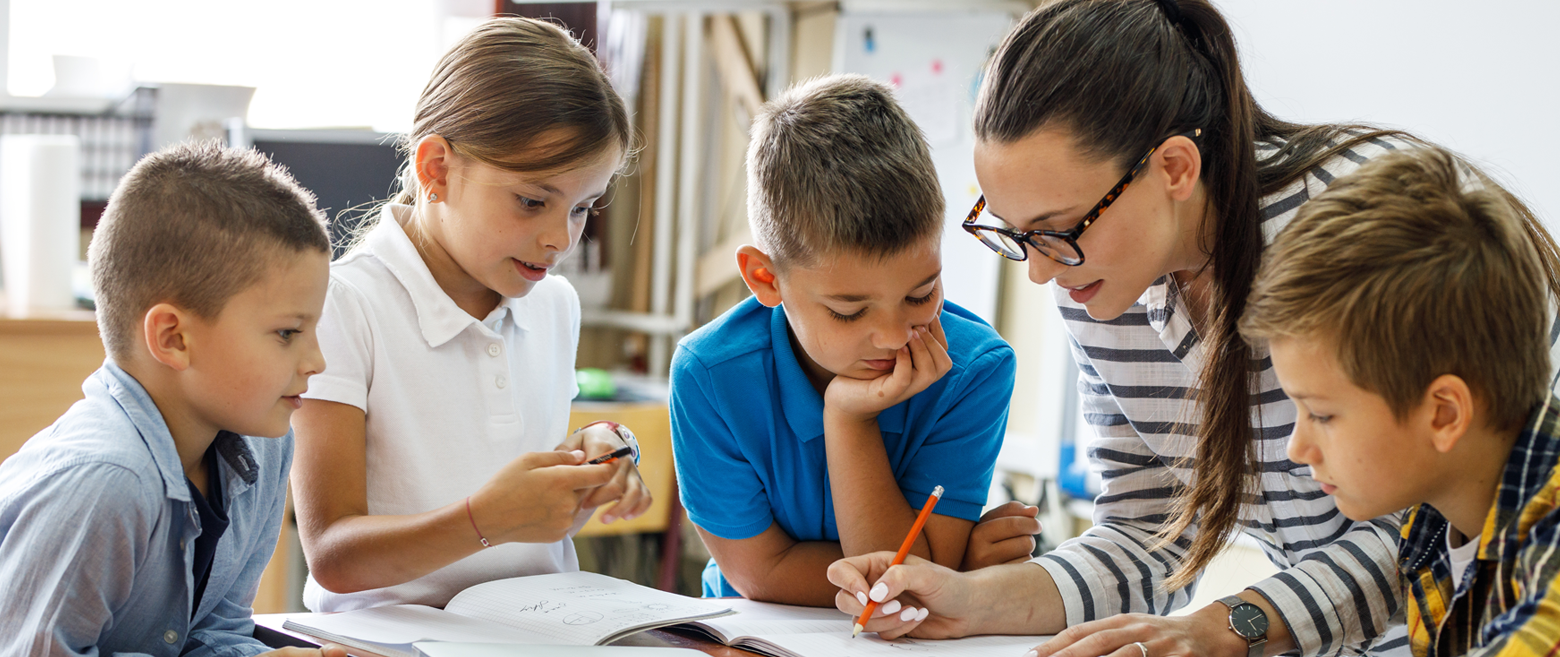 Teacher helping group of kids