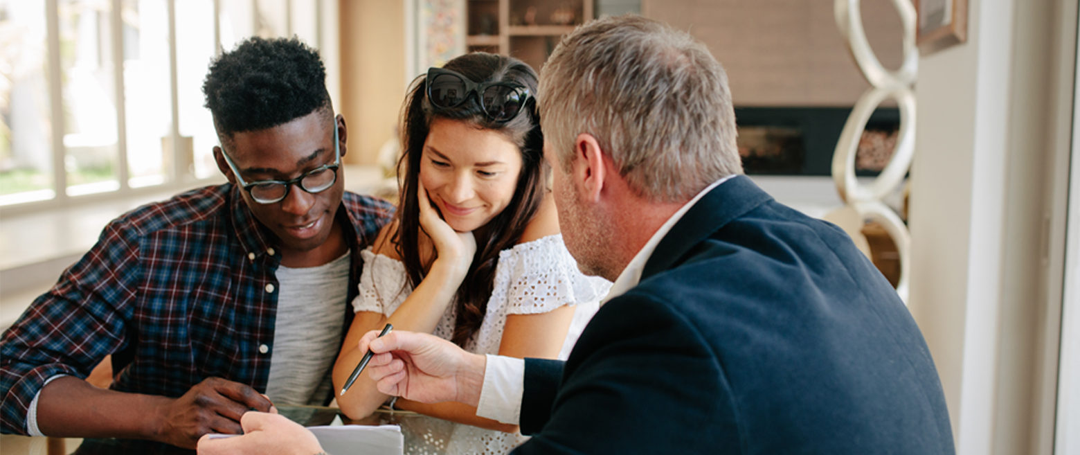 Couple looking a document with a man