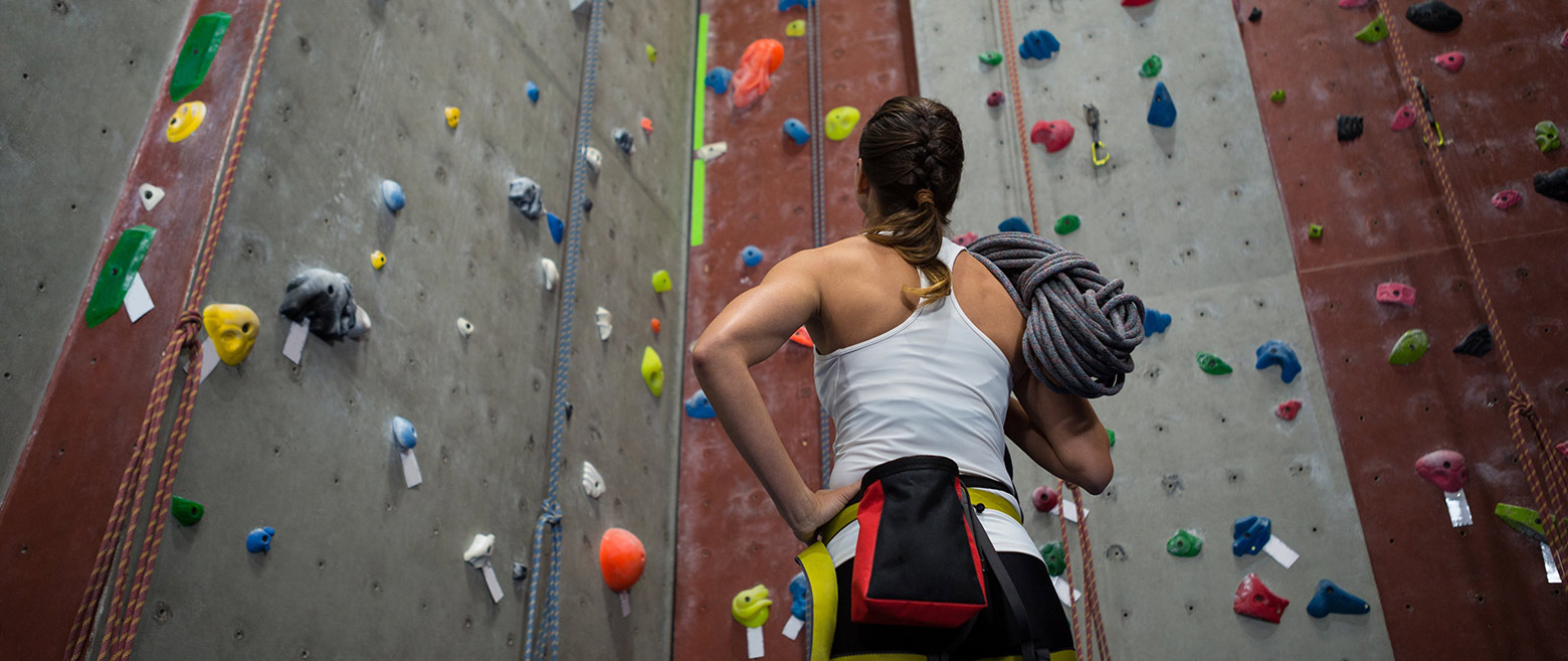 Image of woman near indoor climbing wall.