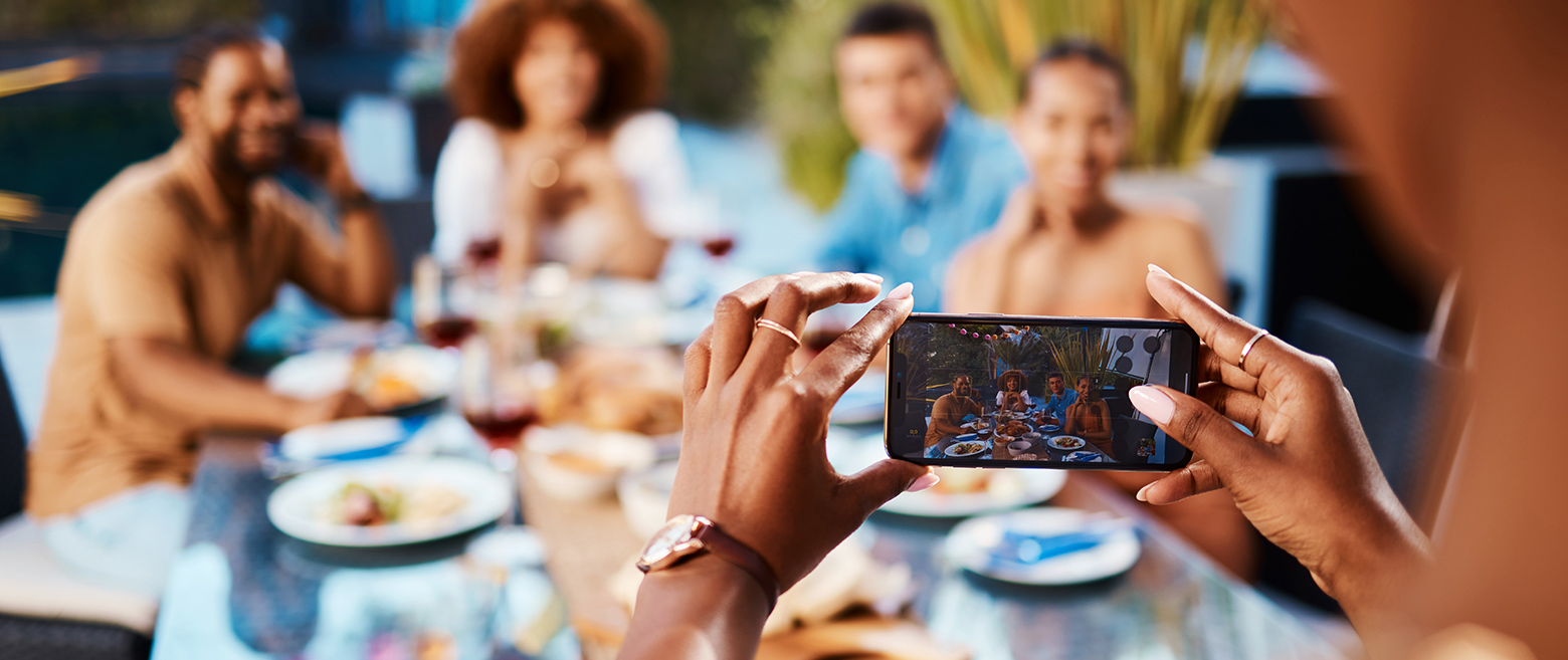 Person taking a photo of a group of people, on a cellphone