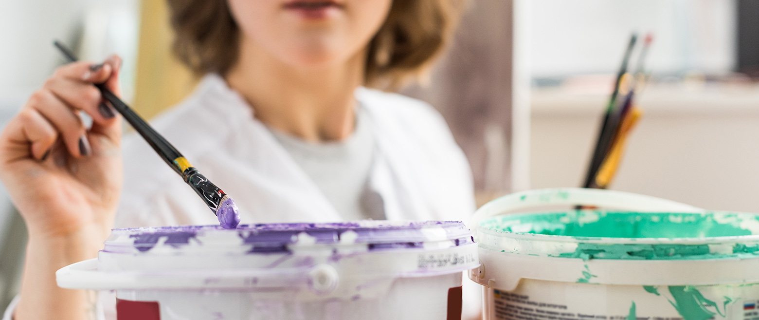 Lady grabbing paint with a paint brush