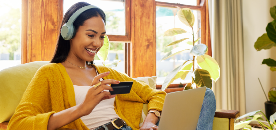 Woman using a laptop and holding her card