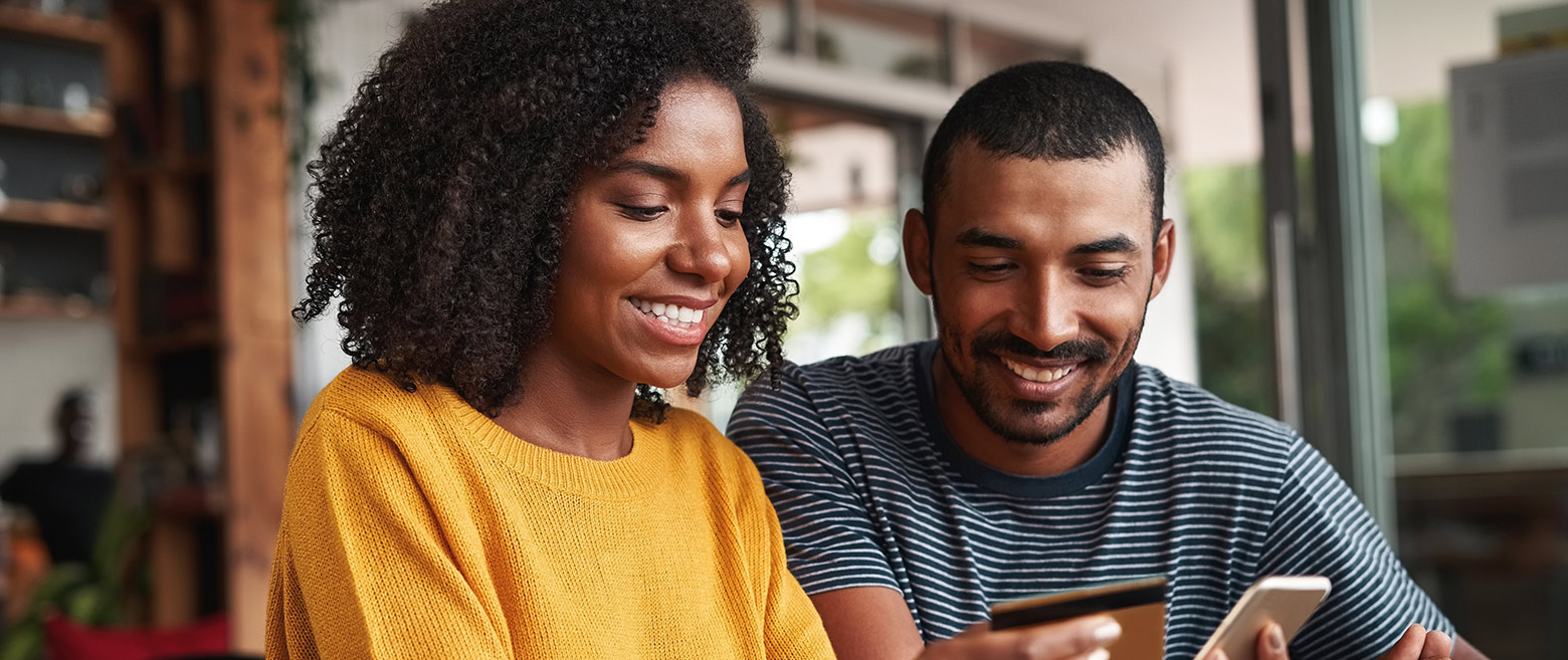 Couple looking at phone and credit card