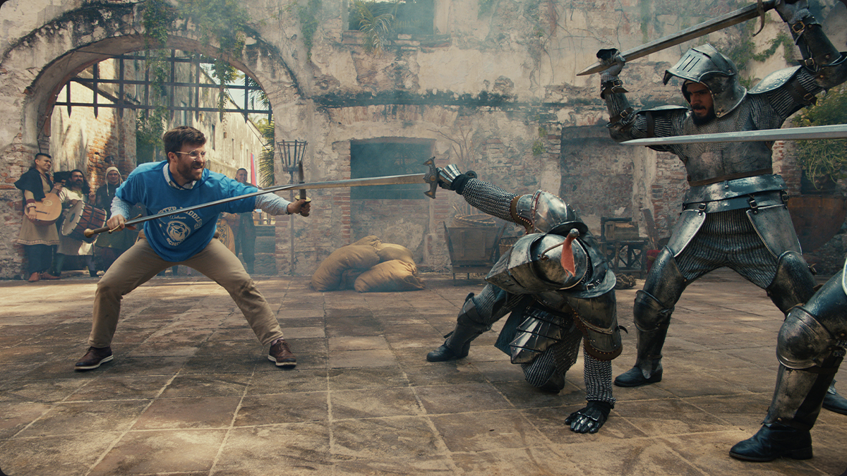 Male teacher dueling against multiple knights showing that there's more to love about E*TRADE