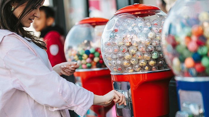 Girl grabbing bubblegum from a bubblegum container
