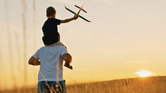 Father and son holding a toy plane