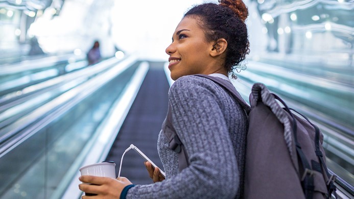 Woman going up escalator and smiling