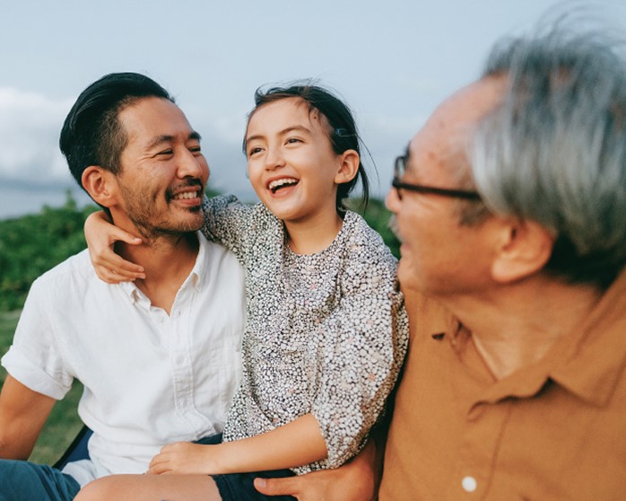 Family smiling at each other outside