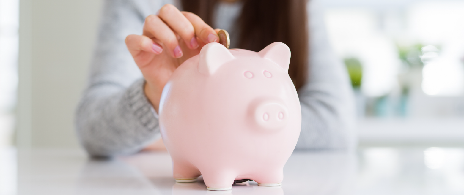 Woman dropping a penny in a piggy bank