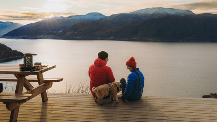 Couple with their dog looking at a mountain view