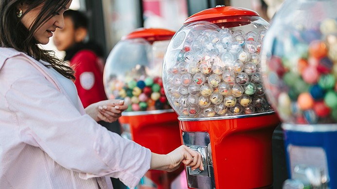 Girl grabbing bubblegum from a bubblegum container