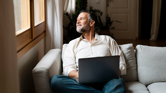 Man on computer looking out window
