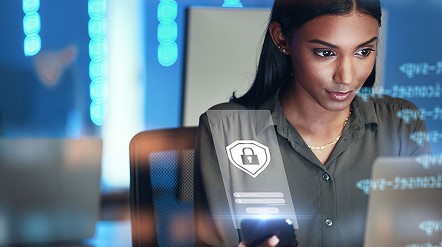 Person working on a laptop with a digital security interface displaying a lock icon and data overlays