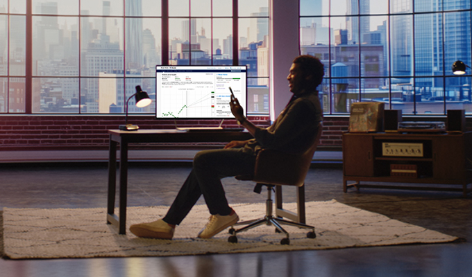 Person reviewing financial plan and investing charts on etrade.com on a desktop monitor